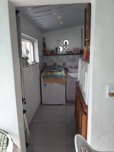 Una cocina con lavadora y secadora en una habitación. en Casa perto do centro, en Garopaba
