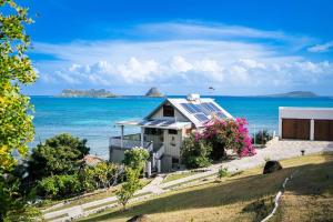 a house with solar panels on top of the ocean at Exclusive Beachfront Eco studio in Hermitage