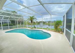 una piscina en una casa con techo de cristal en Beautiful Waterfront Home with Heated Pool and Game Room, en Davenport