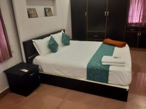MarudhamalaiSremethila Homestay的卧室里有一张大床，配有蓝色枕头