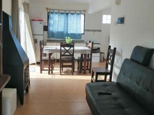 a living room with a couch and a table and chairs at Atlantic 10 in Atlántida