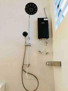 a shower in a bathroom with a shower head at Sarang Homestay - Landed House with 3 Bed Rooms in Ipoh