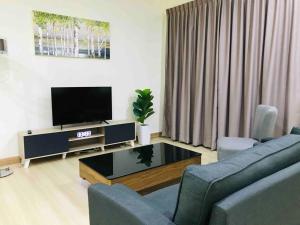 a living room with a couch and a tv at Sarang Homestay - Landed House with 3 Bed Rooms in Ipoh