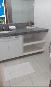 a white bathroom with a sink and a mirror at Carneiros Beach Resort - Apto 214D in Tamandaré