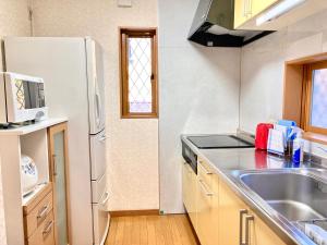 a kitchen with a white refrigerator and a sink at Villa Relax in Fujikawaguchiko