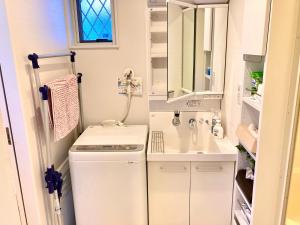 Un pequeño baño con lavabo y lavadora. en Villa Relax, en Fujikawaguchiko 36 fotos más