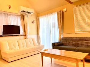 una sala de estar con un sofá y una mesa en Villa Relax, en Fujikawaguchiko