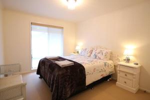 ein Schlafzimmer mit großem Bett und Fenster in der Unterkunft Bridgecroft Cottage in Richmond