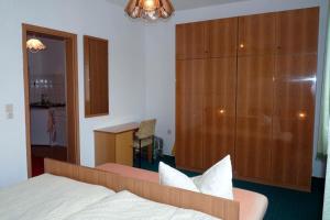 a bedroom with a bed and a large wooden cabinet at Ferienwohnung Tor zur Ostsee in Mellenthin