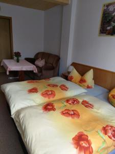 a bedroom with two beds with red flowers on them at Ferienwohnung Tor zur Ostsee in Mellenthin