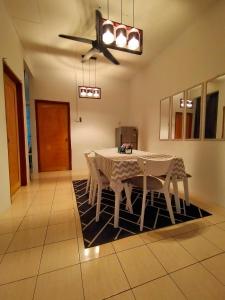 a dining room with a table and chairs on a rug at Kak Zai Homestay Port Dickson With Private Pool in Port Dickson