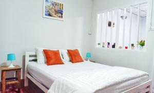 a bedroom with a white bed with orange pillows at whole house for 5 guests 3 beds in Hat Yai