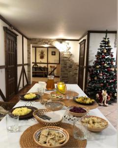 a table with food and a christmas tree in a room at Karpatska Mria in Yaremche