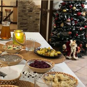 a table with bowls of food and a christmas tree at Karpatska Mria in Yaremche