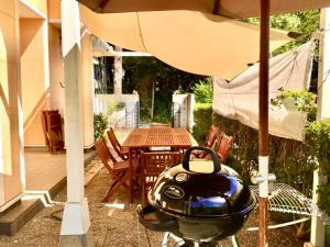 - un barbecue installé sous un parasol sur une terrasse dans l'établissement Villa Relax, à Fujikawaguchiko