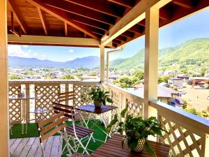 Un balcón con mesa y sillas y montañas. en Villa Relax, en Fujikawaguchiko