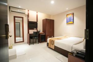 a hotel room with a bed and a desk at Jatra Hotel Grand Royal in Dhaka