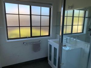 ein Badezimmer mit Waschbecken, Spiegel und Fenster in der Unterkunft Bridgecroft Cottage in Richmond + 10 Fotos