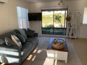 ein Wohnzimmer mit Sofa und Tisch in der Unterkunft Bridgecroft Cottage in Richmond