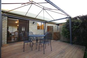 a patio with a table and chairs on a deck at Bridgecroft Cottage - Cosy 2 bedroom cottage in Richmond