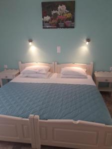a bedroom with a large bed with a blue blanket at Katerina Studios in Paleokastritsa +42 photos