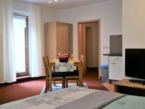 a room with a table with chairs and a kitchen at Am Kirchberg Ferienwohnungen in Kurort Oberwiesenthal