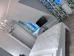 a white room with a bed and a television at Doinita House in Borşa