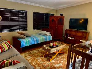 a living room with a couch and a flat screen tv at Douglas Villas in Tzaneen