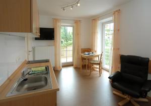 eine Küche mit einer Spüle und einem Tisch mit einem Stuhl in der Unterkunft Haus am Bach in Bad Wörishofen