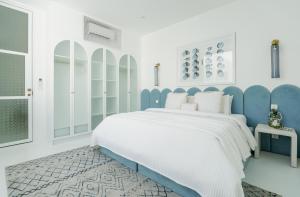 a white and blue bedroom with a large bed at The Cali Villas Canggu in Canggu