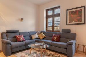 a living room with a blue couch and a table at Post Residence Apartments by All in One Apartments in Zell am See