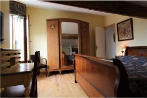 een slaapkamer met een bed, een dressoir en een spiegel bij Gite le grenier des maraichers in Albigny-sur-Saone