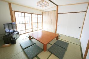 a small room with a wooden table and two chairs at Y's あたみんち in Atami