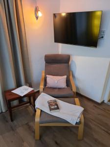 Zimmer mit einem Stuhl und einem TV an der Wand in der Unterkunft Ferienwohnung Huber in Söll