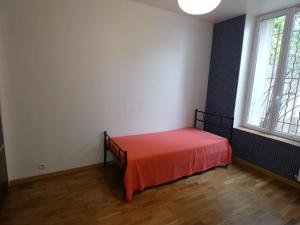 Appartement Charmant, quartier calme في نانسي: غرفة بسرير عليها شرشف احمر