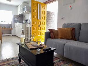 a living room with a couch and a table with wine glasses at Casa TRIGO in Cómpeta