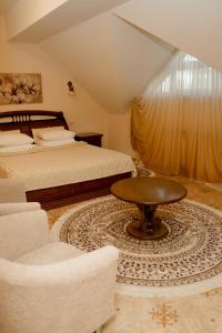 a bedroom with two beds and a table and chairs at Kremlyovsky Hotel in Suzdal