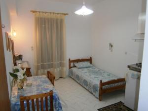 a small room with a bed and a table with a tableablish at Matina's house in Samos