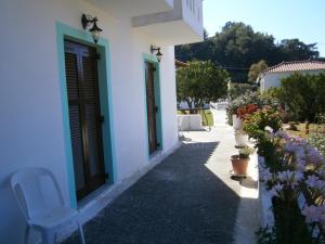 un edificio blanco con una puerta azul y una silla en Matina's house en Samos