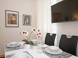 stół z talerzami, miskami i kwiatami w obiekcie Ferienwohnung Klimt w Wiedniu