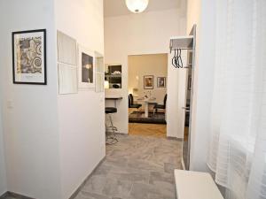 a hallway with a white wall and a living room at Ferienwohnung Klimt in Vienna