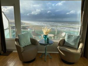 een kamer met 2 stoelen en een tafel met uitzicht op de oceaan bij Annet's Studio in Zandvoort