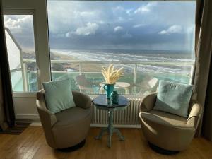 a room with two chairs and a table with a view of the ocean at Annet's Studio in Zandvoort