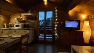 een keuken met een televisie en een tafel met een tafel sidx sidx sidx bij mini duplex dans chalet in Saint-François-Longchamp