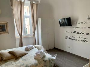 a bedroom with a bed and a tv on the wall at Guest House Casa Vicenza in Rome