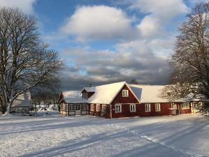 a red barn with snow on its roof at SOEDER Countryhouse & Kitchen in Båstad