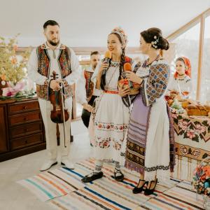 um grupo de pessoas em roupas ucranianas cantando em Cabana din Dealul Cucului em Năsăud
