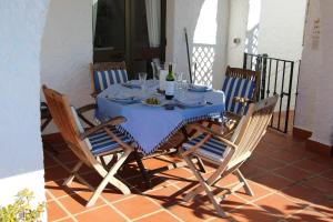 een blauwe tafel met stoelen en een fles wijn bij El Capistrano Village Spacious home, large terrace in Nerja