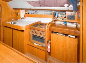 a kitchen with a stove and a sink at Cosy Sailing Boat Glamping Accommodation on the River in Sandwich in Sandwich