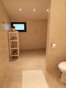 uma casa de banho com um WC e uma janela em Algarte Guest House em Madzhare